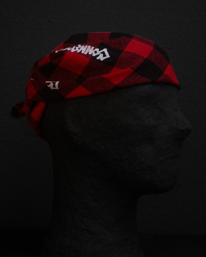 Red and black checkered bandana with branding on a dark background