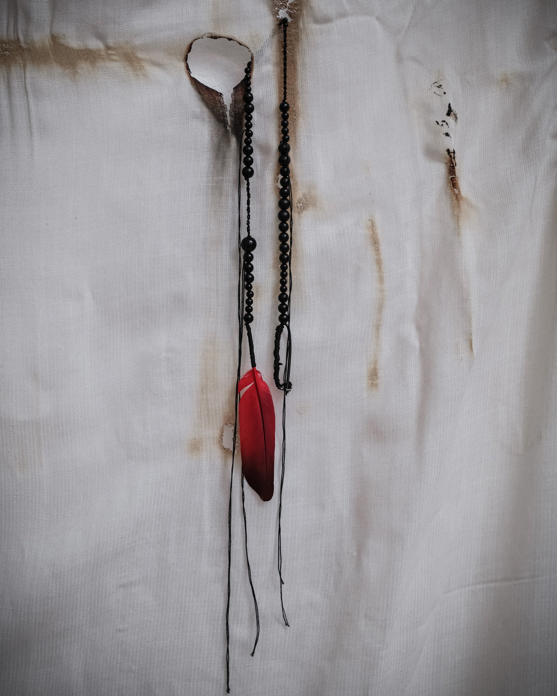 Ann Demeulemeester SS2017 runway necklace with black beads and red feather detail