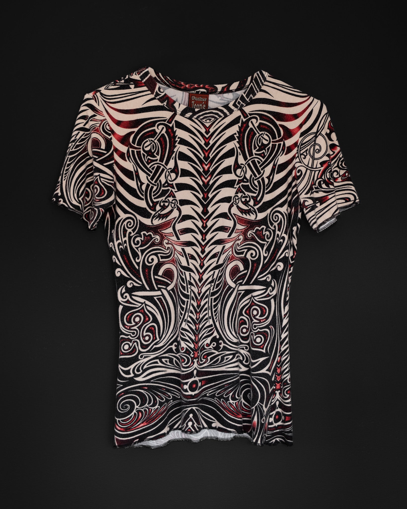 Jean Paul Gaultier Cyberbaba 1996 tribal tattoo tee in off-white with black and red print, fitted stretch viscose top with exposed overlock seams
