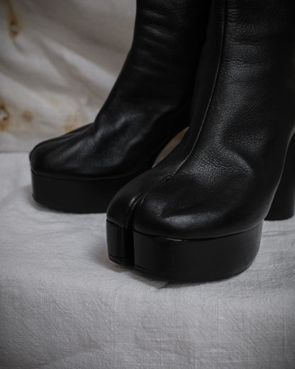 A pair of Maison Margiela Black leather tabi boots with platform heel, close-up